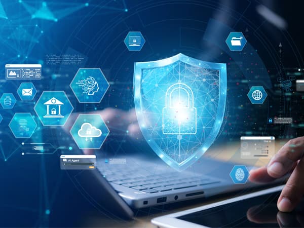 Digitale IT-Sicherheit: Leuchtender Schutzschild mit Schloss über einem Laptop