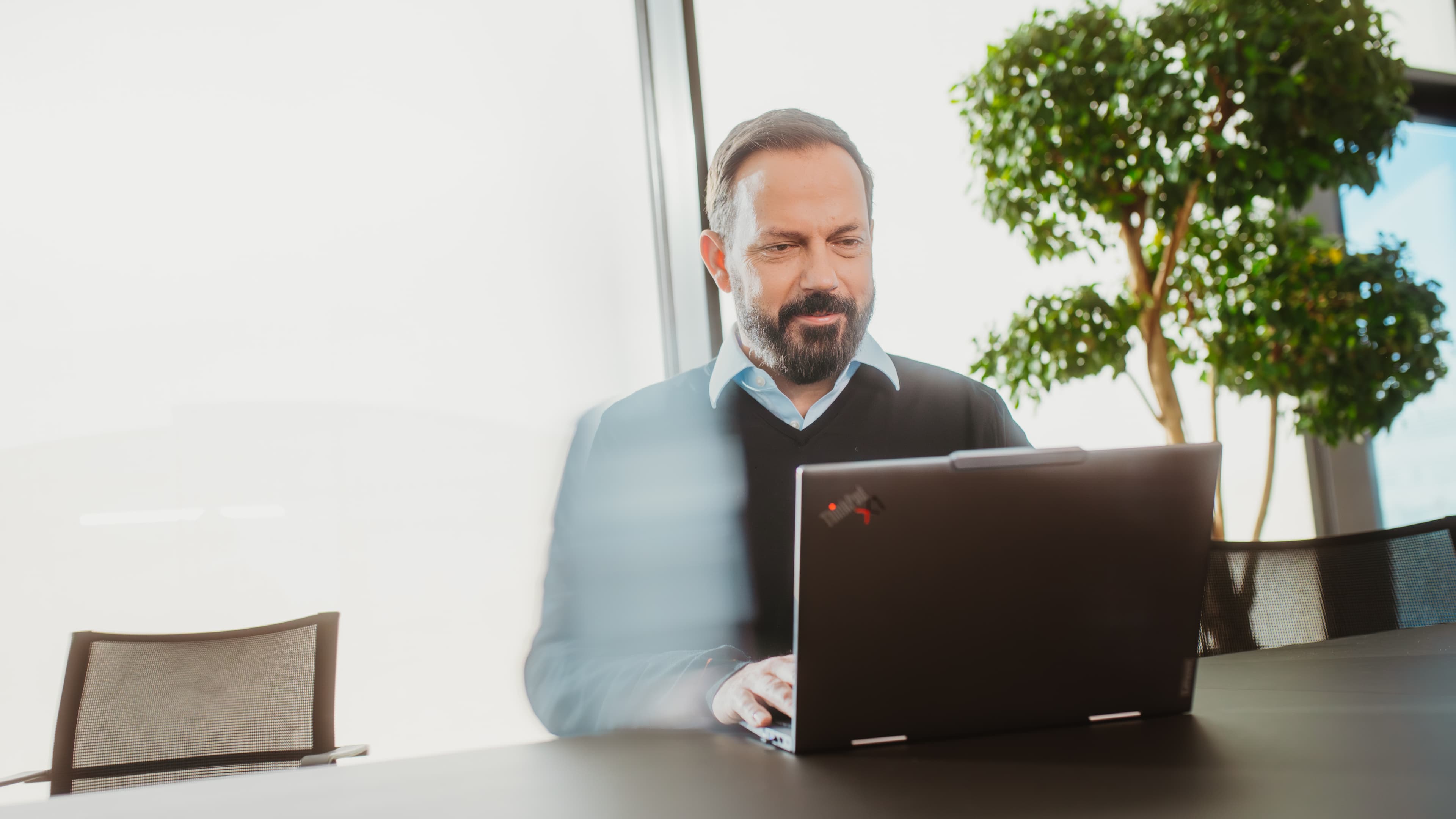 Mitarbeiter im IT-Management arbeitet in einem Besprechungsraum an einem Laptop