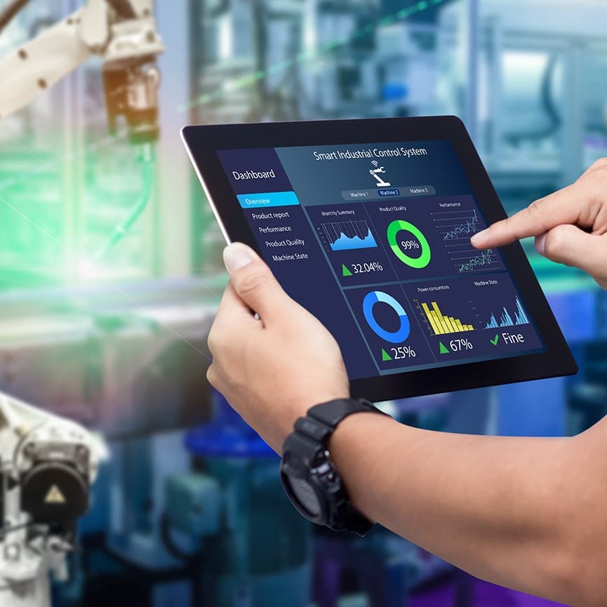 Person bedient ein Tablet mit Dashboard neben einem Industrieroboter.