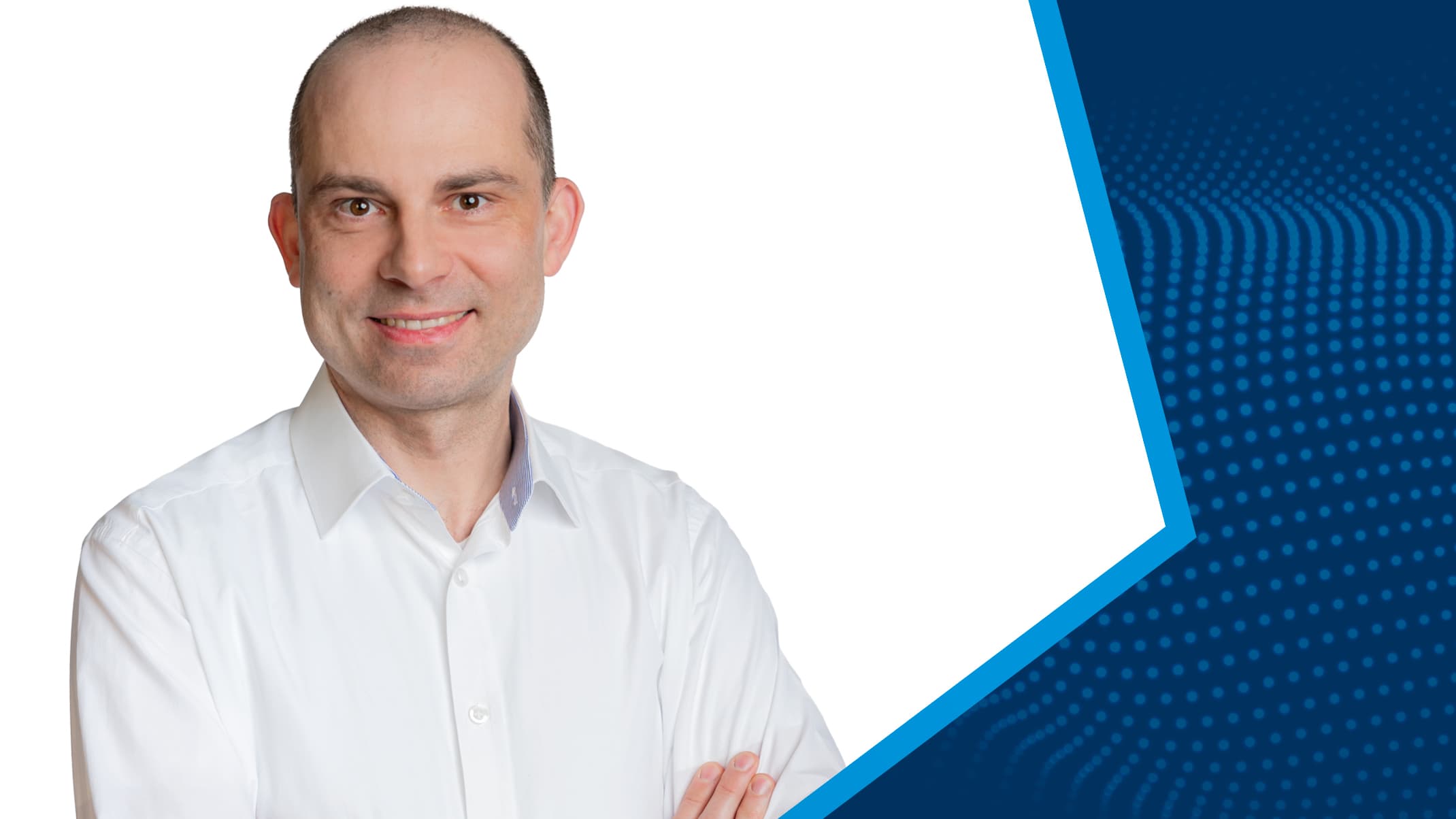 Porträt von Philipp Spangenberg im weißen Hemd vor blau-weißem Hintergrund