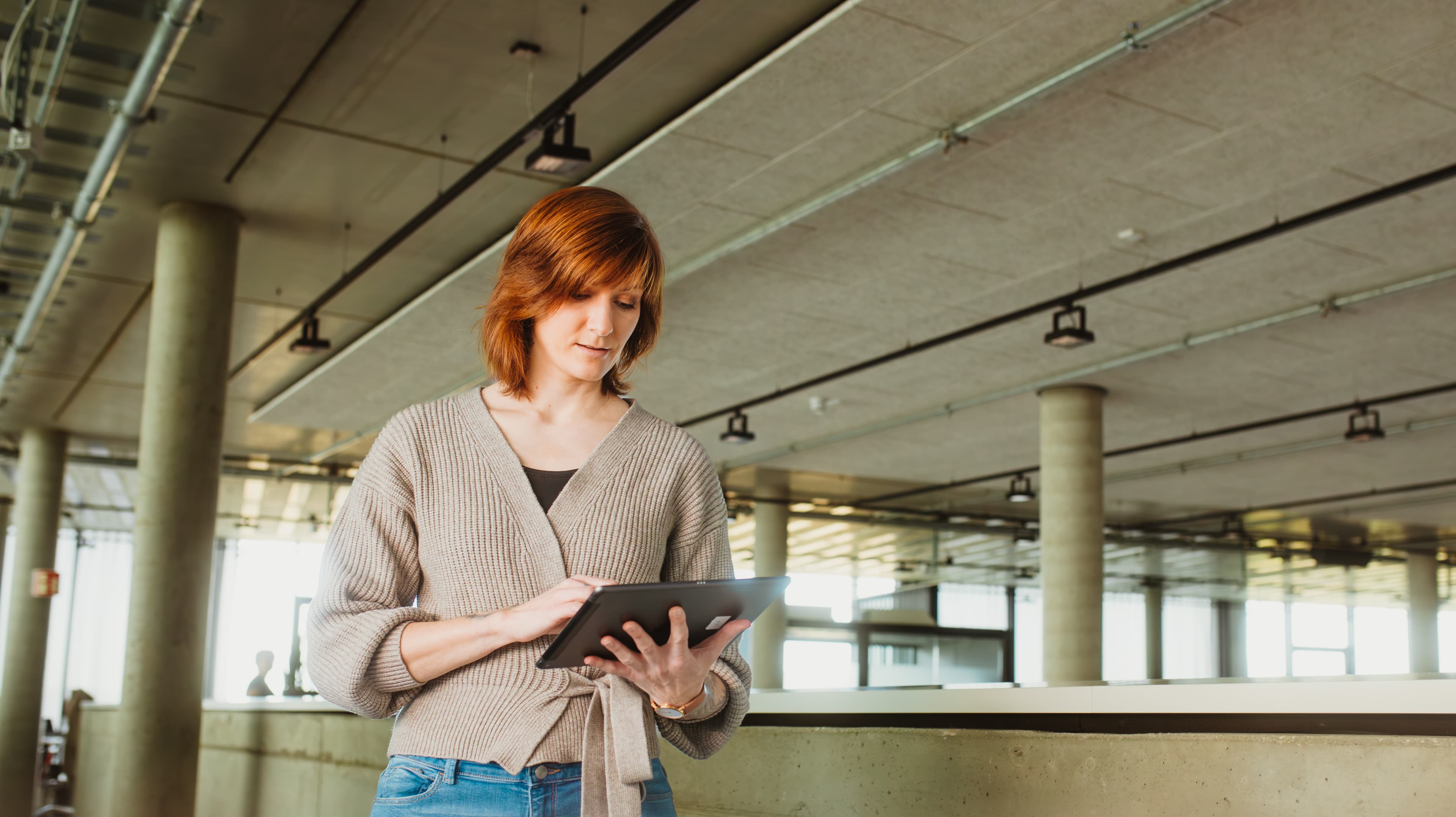 Mitarbeiterin nutzt ein Tablet in einem modernen Büro für das IT-Management