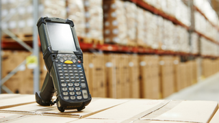 Handscanner auf einem Stapel von Kartons in einem Lager