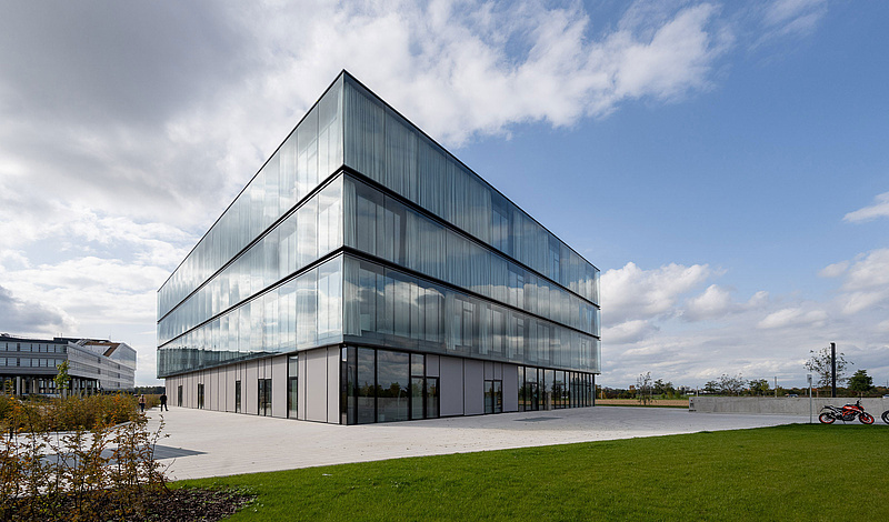 Modernes Bürogebäude der baramundi SoftwareFactory mit Glasfassade und grüner Umgebung