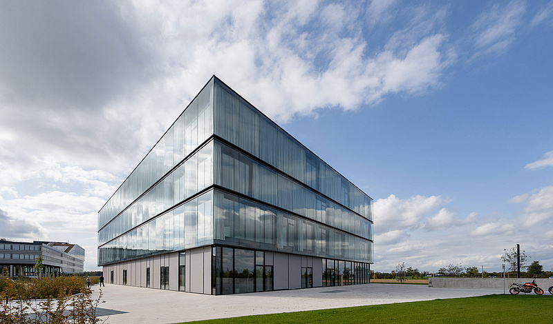 Modernes Bürogebäude der baramundi SoftwareFactory mit Glasfassade und grüner Umgebung