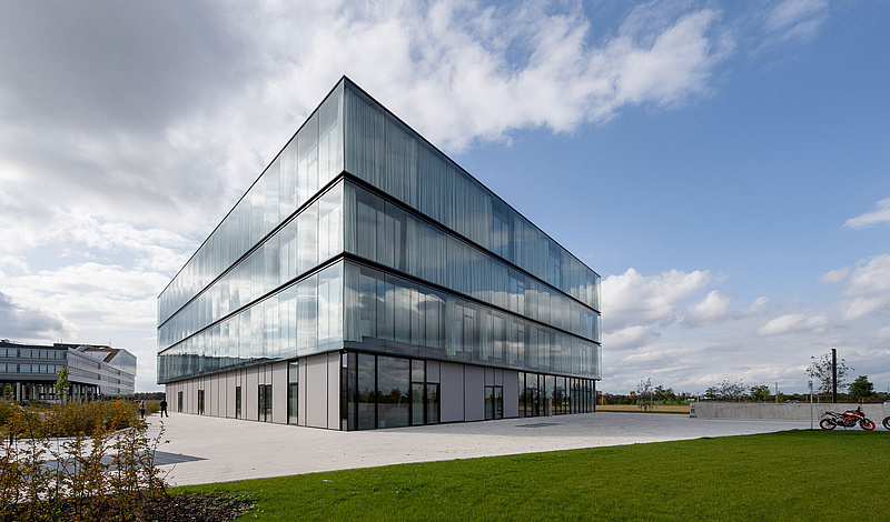 Modernes Bürogebäude der baramundi SoftwareFactory mit Glasfassade und grüner Umgebung