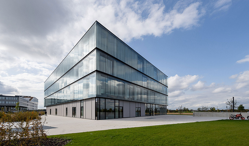 Modernes Bürogebäude der baramundi SoftwareFactory mit Glasfassade und grüner Umgebung